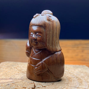 Netsuké ningyō en bois représentant une femme avec un fruit.